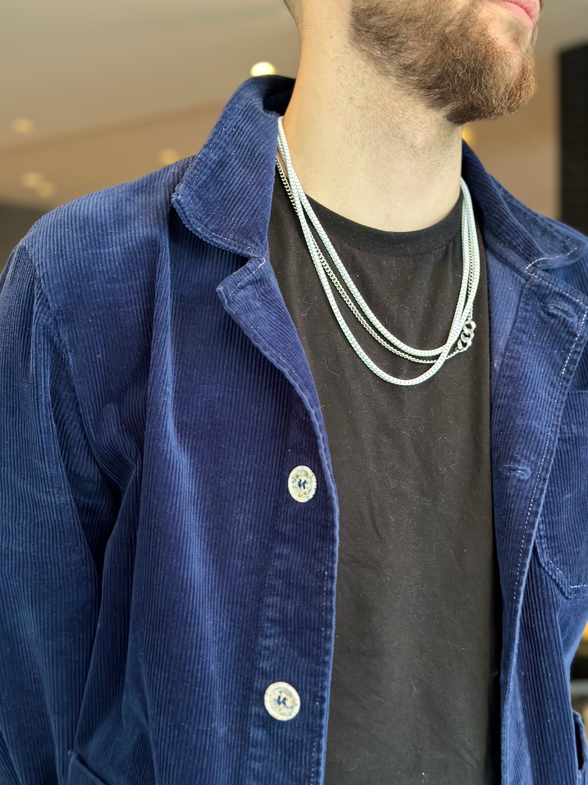 mens model wearing box snake chain necklace and rhythm necklace layered up together